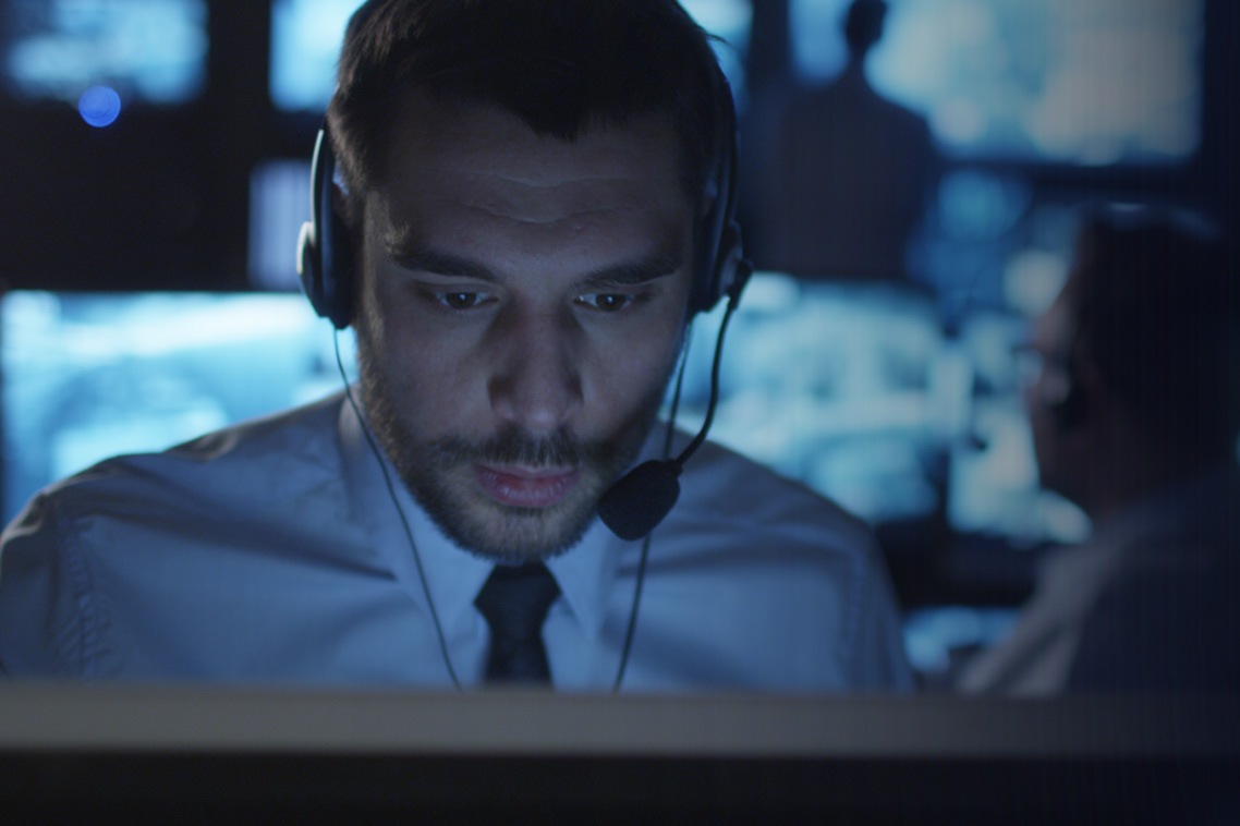 Security representative with headset on a computer